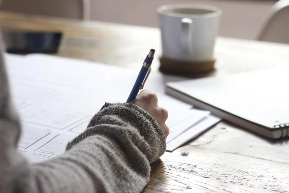 Hand mit Stift über einem Grundriss